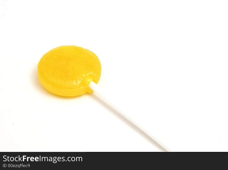 Picture of a yellow lollipop on white