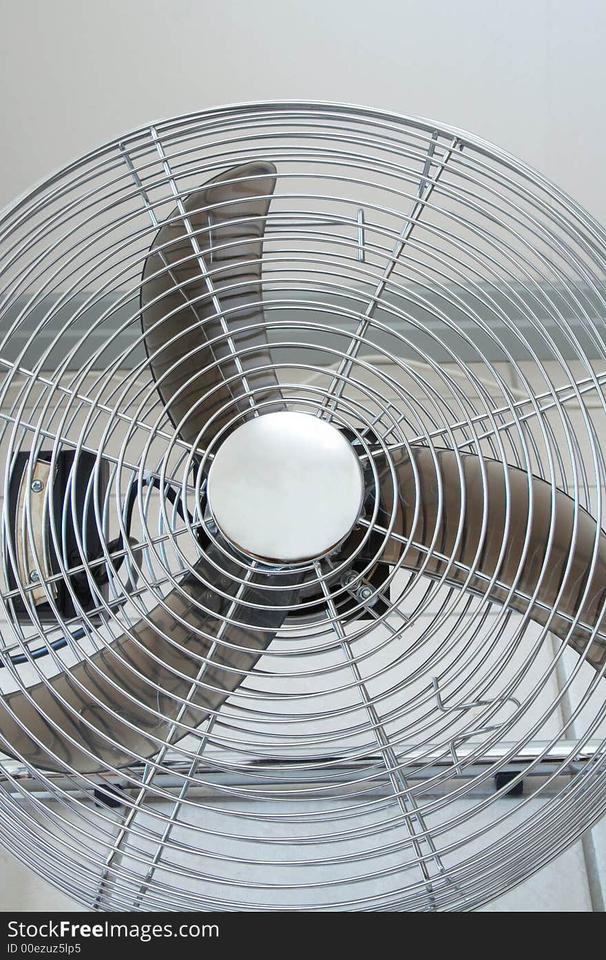 Metal floor fan standing on tiled floor in the house