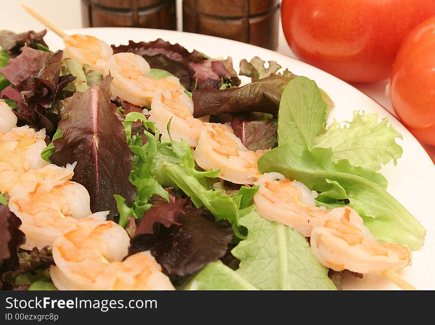 Shrimp skewers on salad