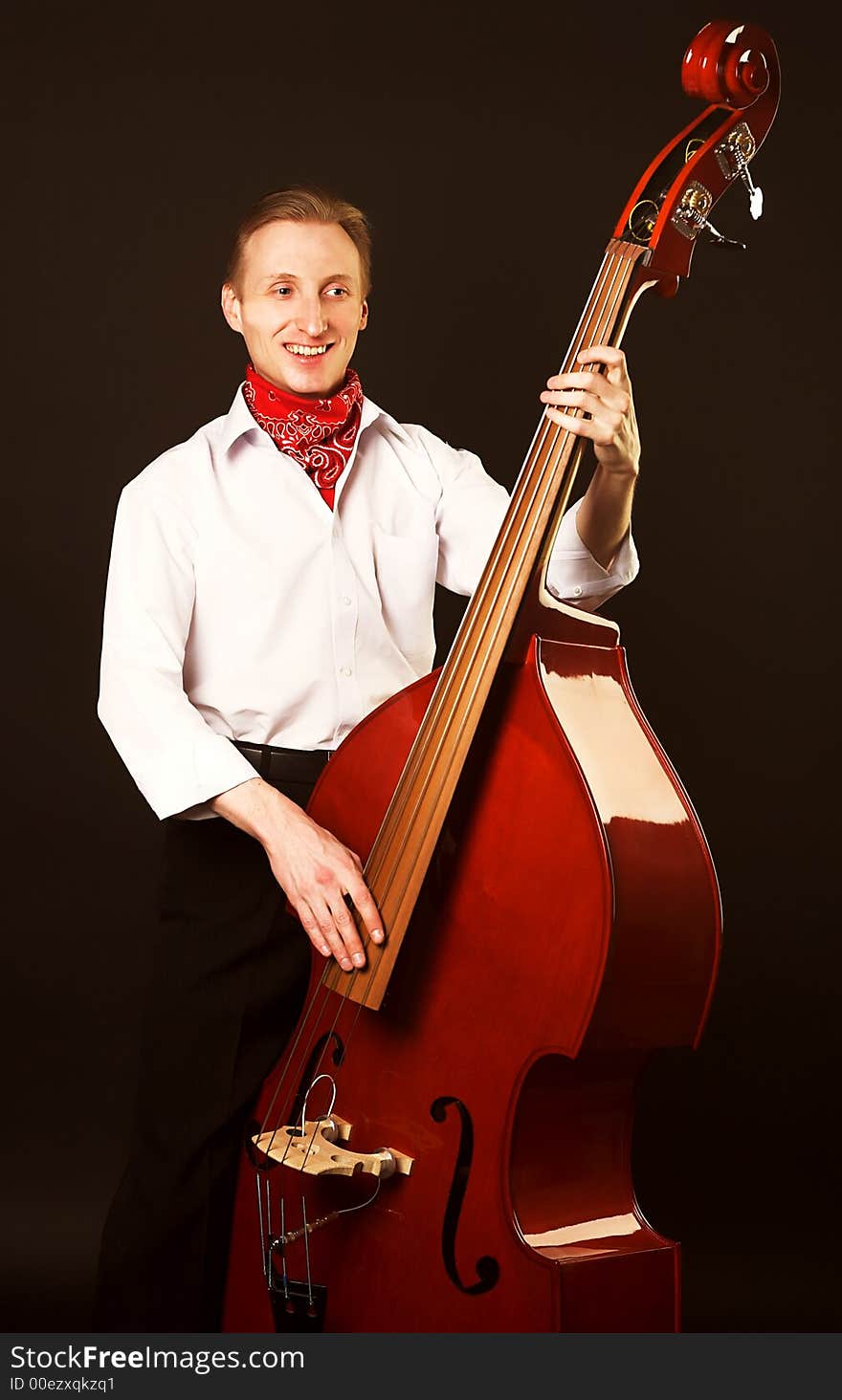 Musician with contrabass. Over black background.