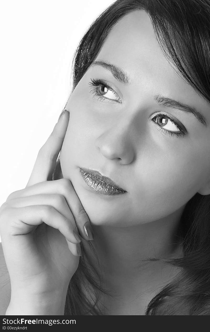 Portrait of the beautiful girl put the face on a hand and holding a finger on a cheek over white background