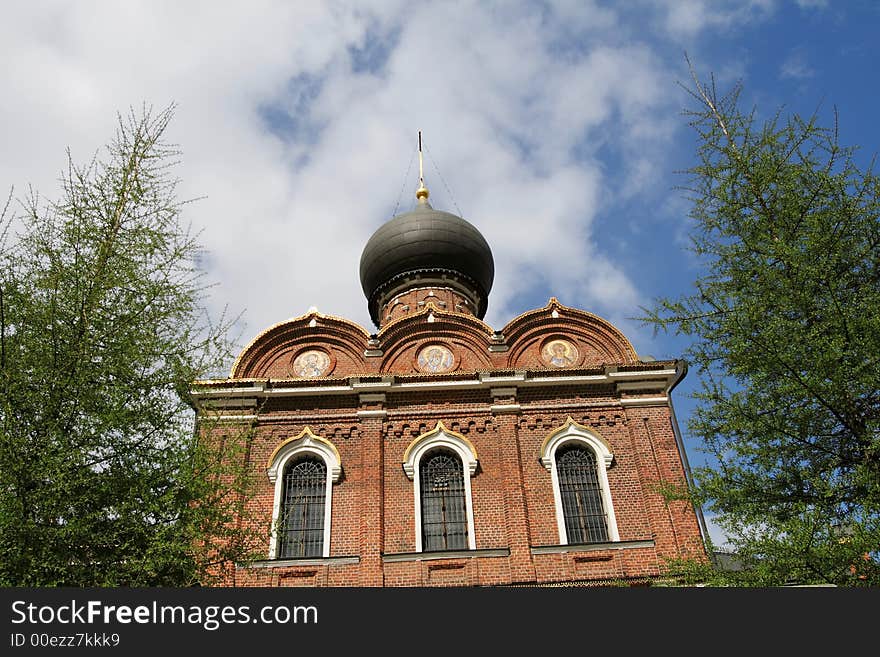 Brick church between green trees, Russia, Moscow. Brick church between green trees, Russia, Moscow