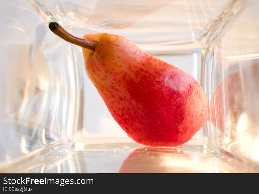 A bit of red ripe pear in a glass box. A bit of red ripe pear in a glass box