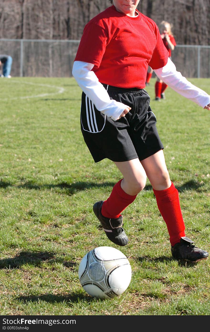 Girl chasing soccer ball down the field. Girl chasing soccer ball down the field.