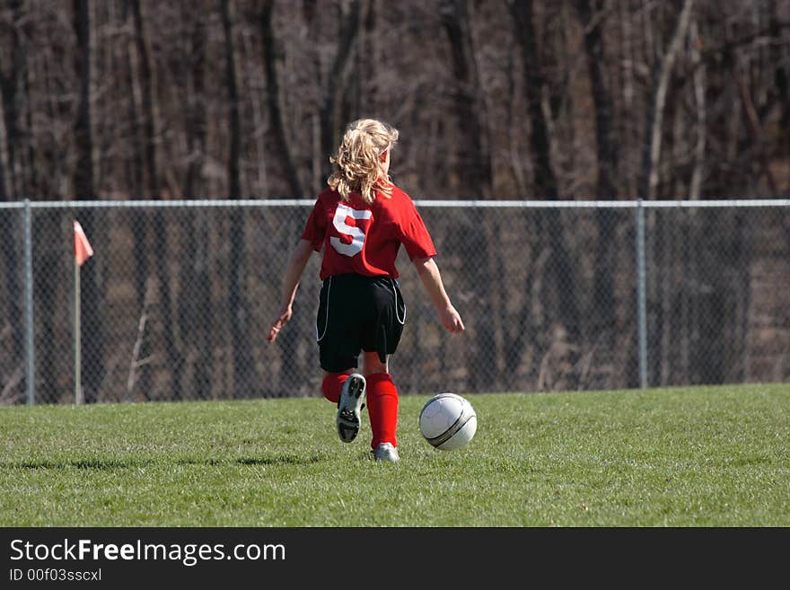 Girls chasing soccer ball down the field. Girls chasing soccer ball down the field.