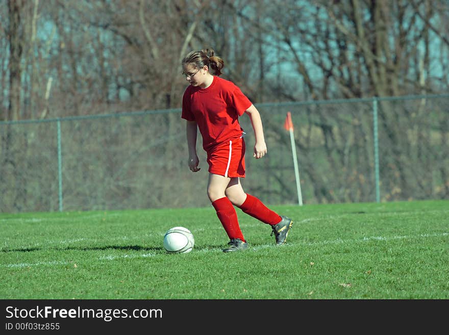 Girl chasing soccer ball down the field. Girl chasing soccer ball down the field.