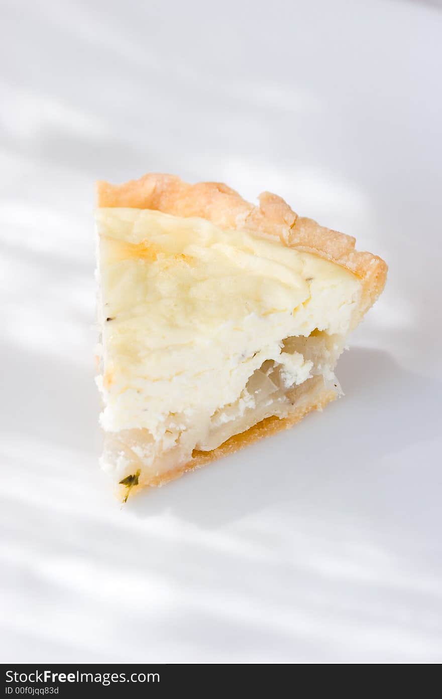 A slice of Goat cheese and onion tart with flour crust. A slice of Goat cheese and onion tart with flour crust