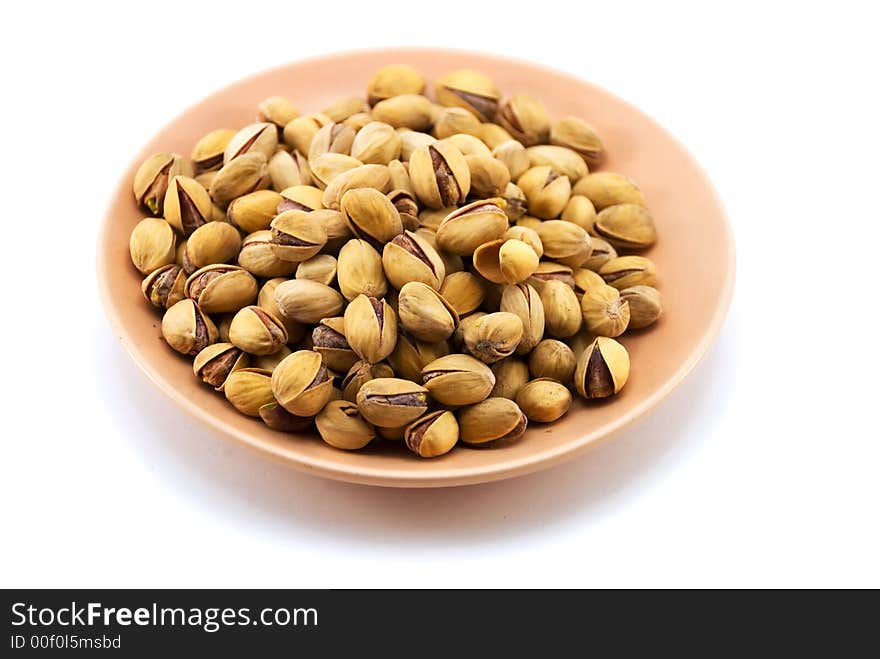 Beautiful pistachioes in a plate on a white background