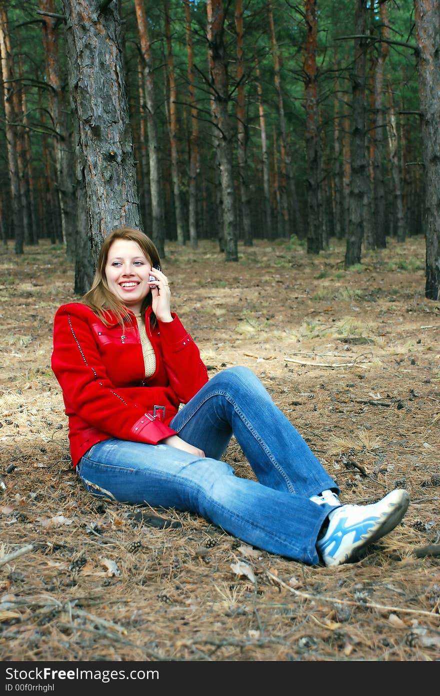 Girl talk for phone sitting under tree