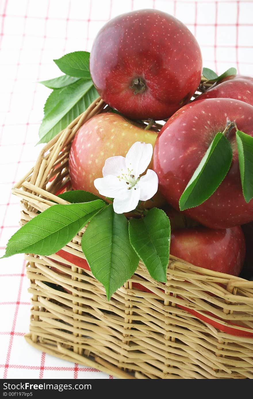 Red apples and white flower in a basket. Red apples and white flower in a basket