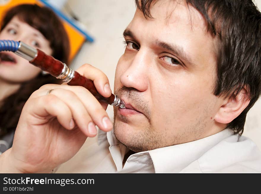 The man lights up a hookah at evening-party