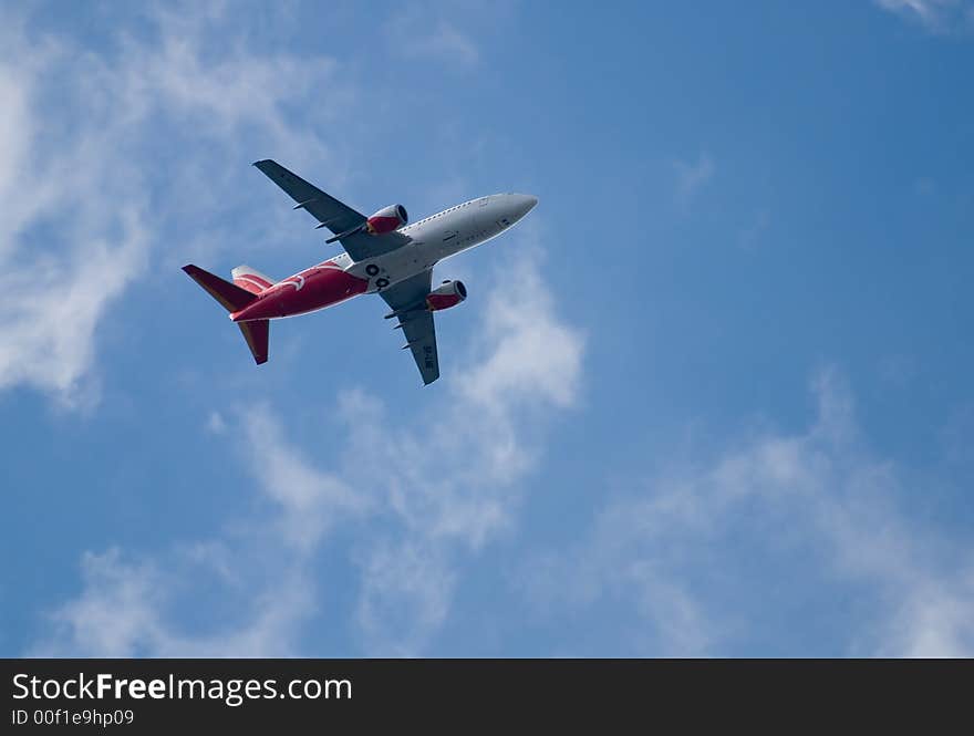 Jet on the cloudy blue sky