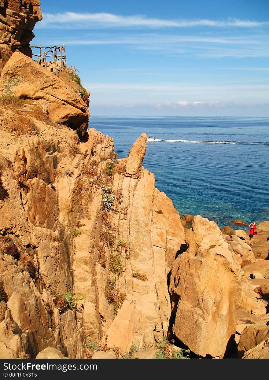 A photographer in the bottom right who is taking a picture of these wonderful rocks in Sardinia (Italy)