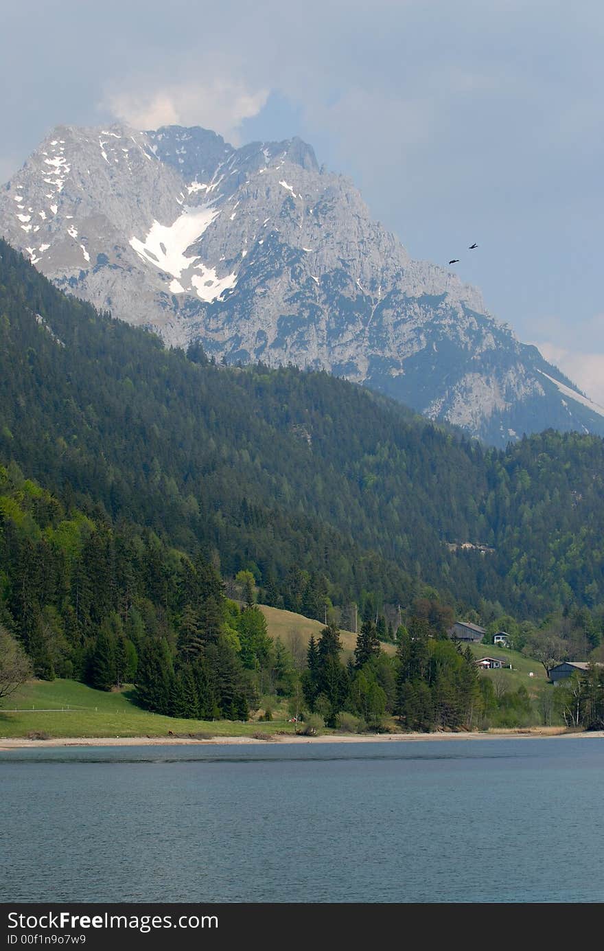 Alps lake with the rock and birds on background. Alps lake with the rock and birds on background