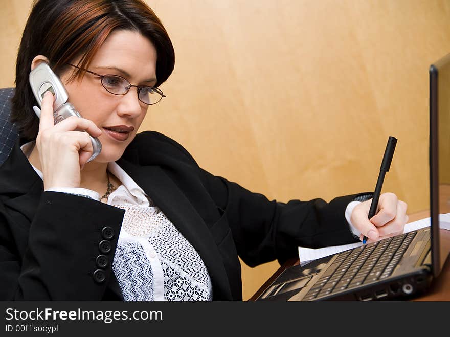 Busy woman on the phone and on her laptop. Busy woman on the phone and on her laptop