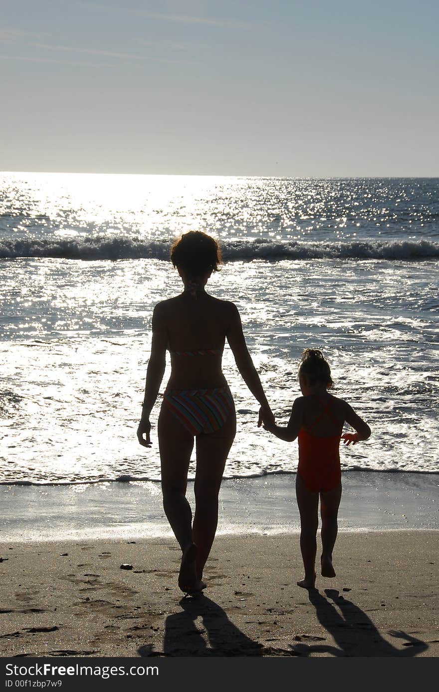 Mother and child on the beach at sunset. Mother and child on the beach at sunset