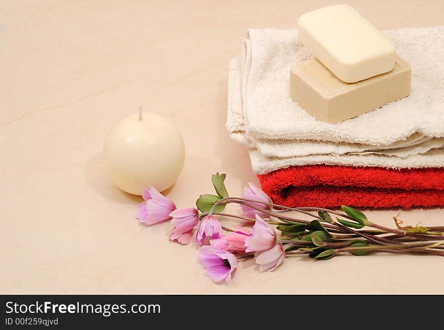 Red and white towels and honey soaps with candle in spa bathroom (spa concept )