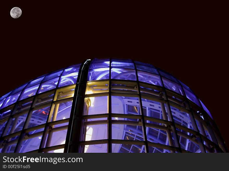 Night shot of glass office building window glass lit with blue purple light room for type above building. Night shot of glass office building window glass lit with blue purple light room for type above building