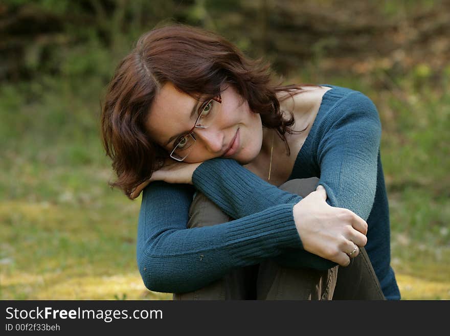 A young girl is relaxing in a grass. A young girl is relaxing in a grass