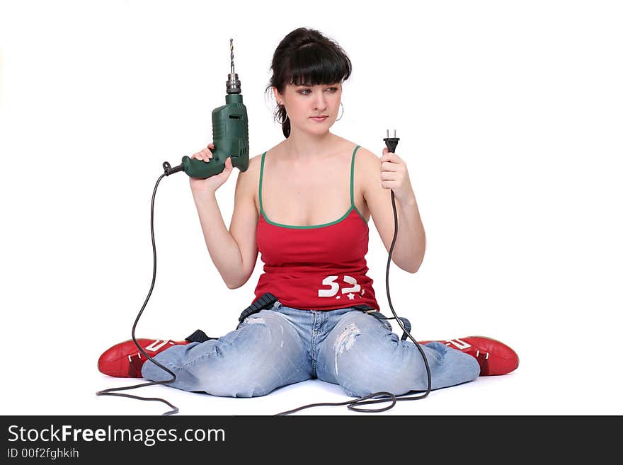 A woman sits and looks at the drill's flex with incomprehension. White background. A woman sits and looks at the drill's flex with incomprehension. White background.