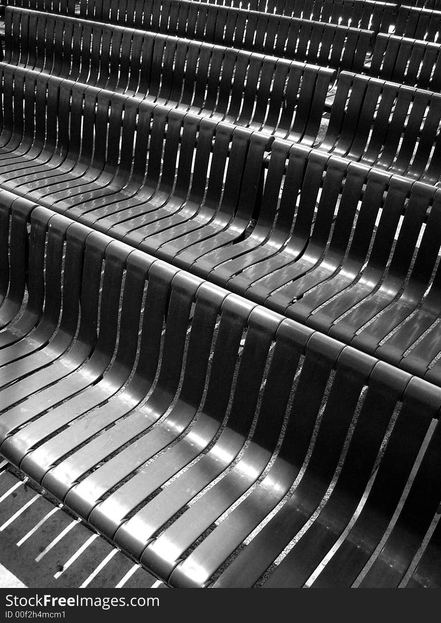 In front of black benches lined up in a angles bias pattern. In front of black benches lined up in a angles bias pattern