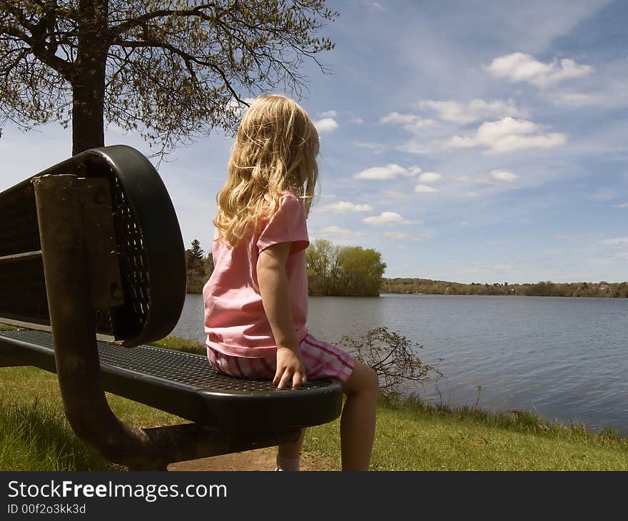 Girl sitting by lake