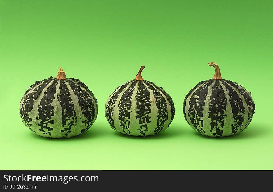 Three pumpkins on green background 1