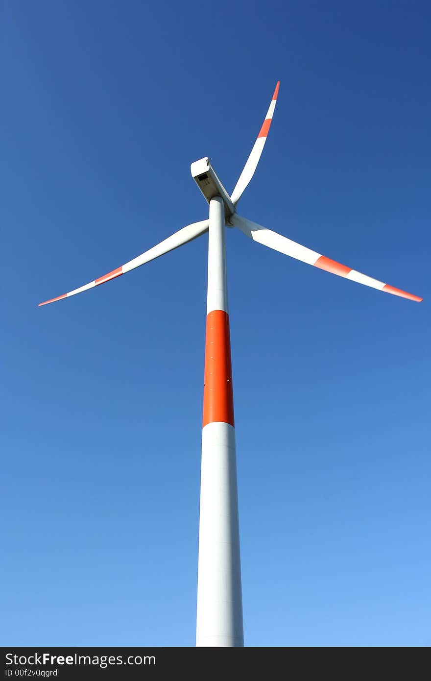 A red/ white windmill against a clear blue sky. A red/ white windmill against a clear blue sky