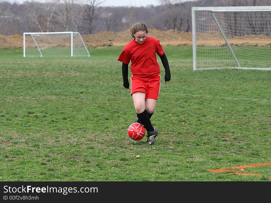 Girl chasing soccer ball down the field. Girl chasing soccer ball down the field.