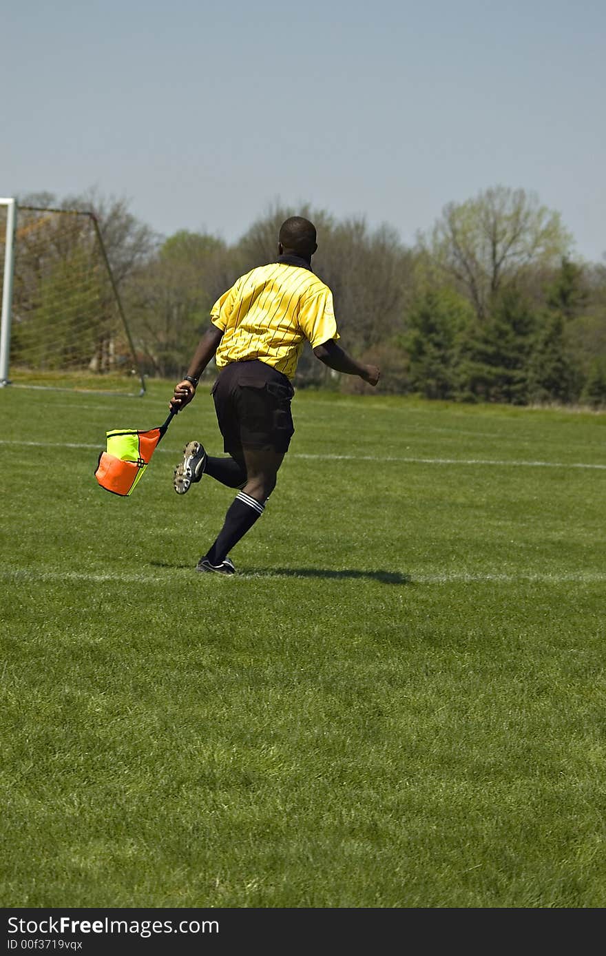 Soccer Official running with flag along side line. Soccer Official running with flag along side line