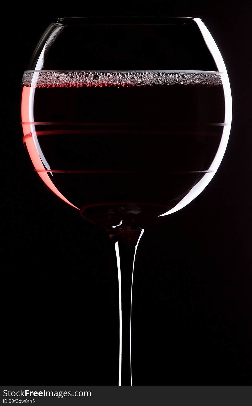 Portrait orientation of a glass of red wine with a black background. Portrait orientation of a glass of red wine with a black background.