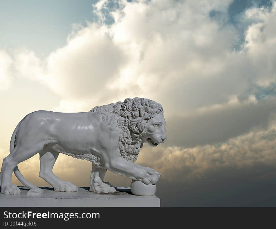 Sculpture of a white lion on a background of the sunset sky