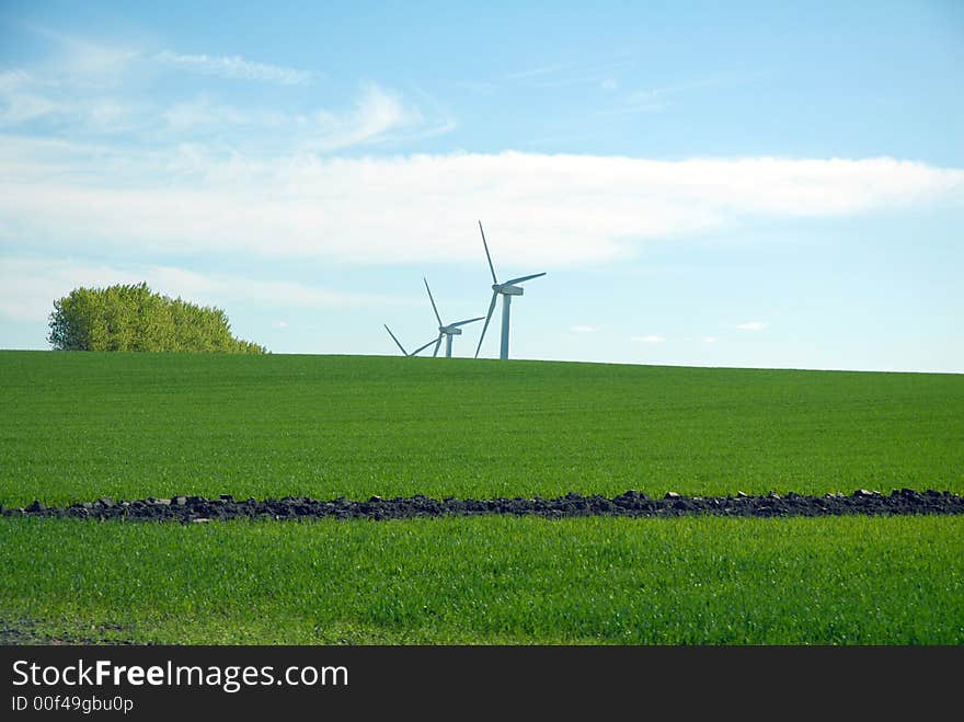 Wind dynamo, green grass and blue sky