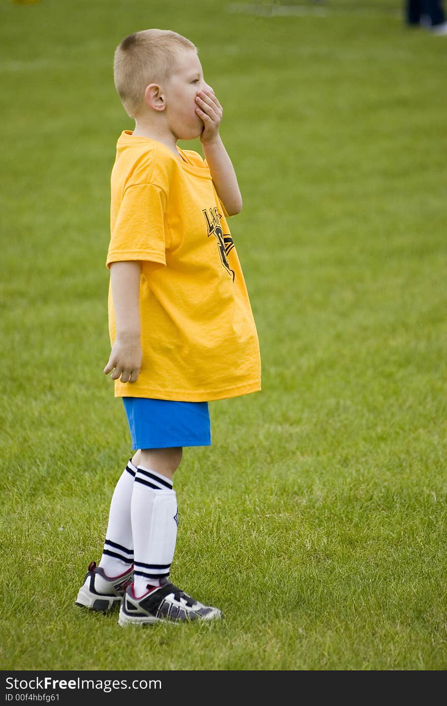 Here is a photo of a young boy playing soccer.  He is either bored or something astonishing just happened!. Here is a photo of a young boy playing soccer.  He is either bored or something astonishing just happened!