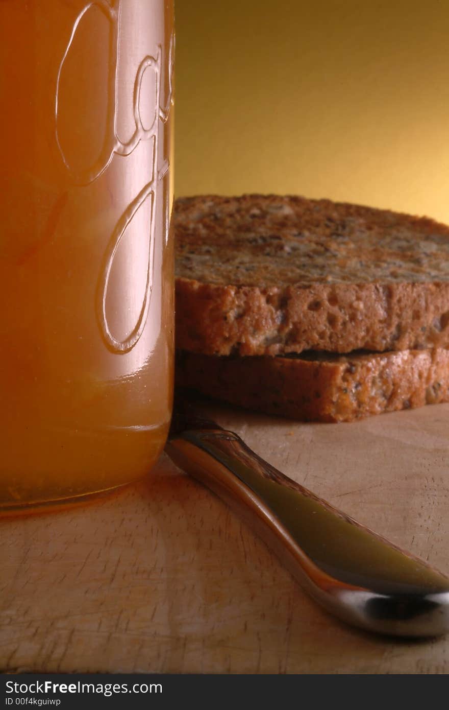 Cosy closeup of toast, marmalade and knife on a wooden board with homestlye cottage feel. Cosy closeup of toast, marmalade and knife on a wooden board with homestlye cottage feel