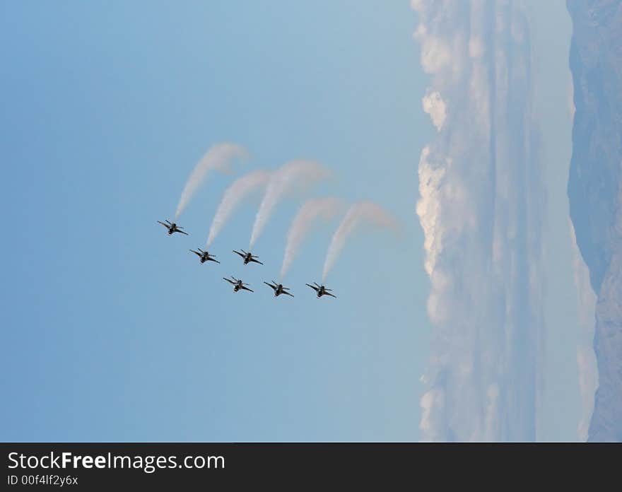 Six fighter jets flying in formation against a clear blue sky