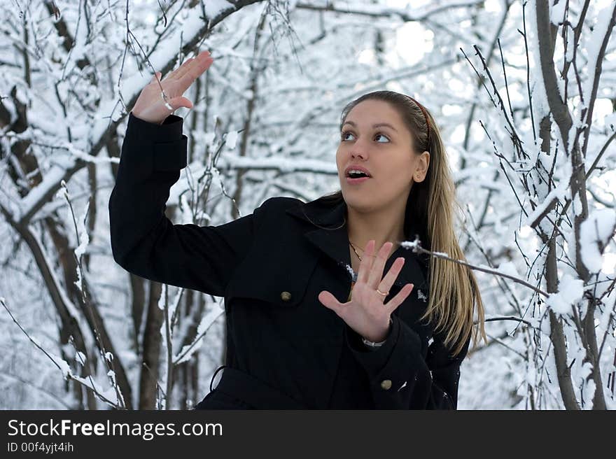 Young girl in winter wood in black raincoat. Young girl in winter wood in black raincoat