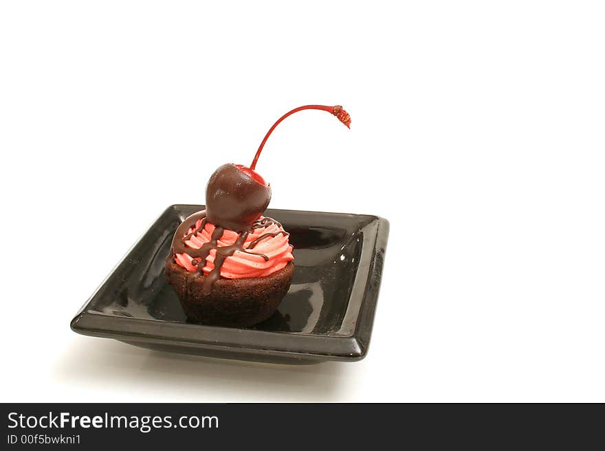 Isolated photo of a cherry topped brownie bite on white