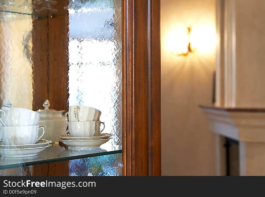 Tea cups behind glass in a kitchen case