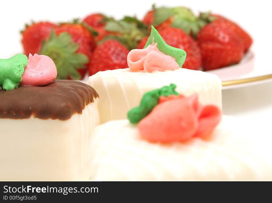 Isolated photo of a petit fours and strawberrys on white