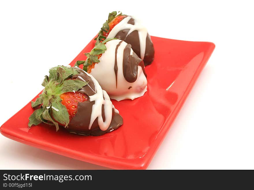 Isolated photo of chocolate covered strawberrys on a red plate on white