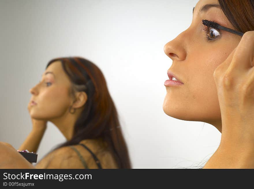 Young beautiful girl applies makeup