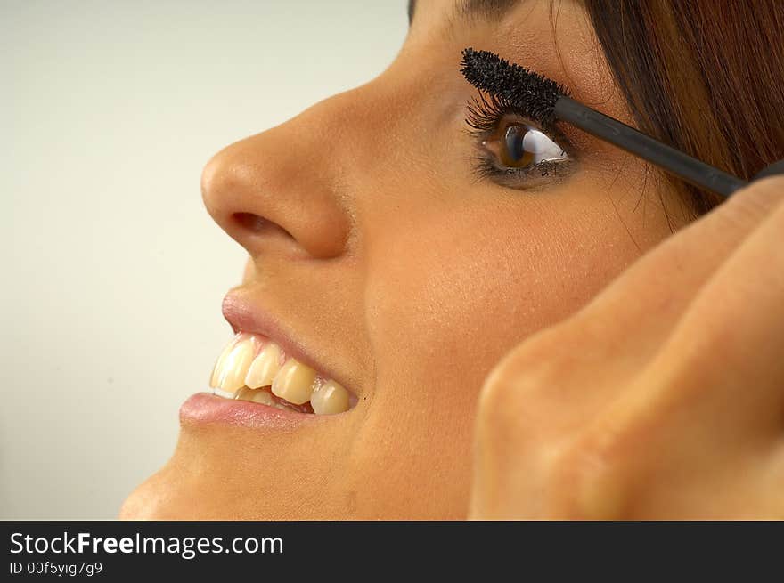 Beautiful girl applies makeup