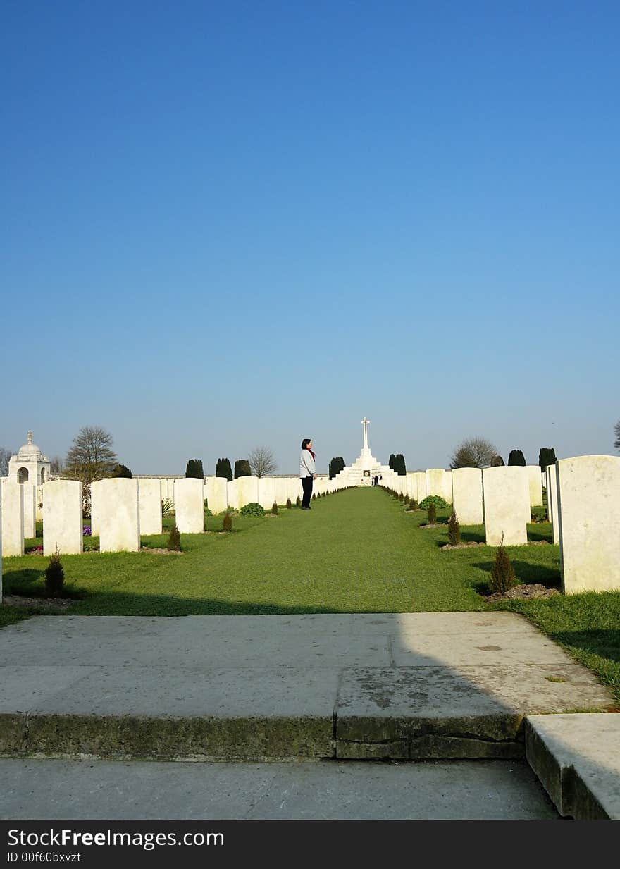 A solitary figure walks up between rows and rows of white headstones in a cemetery filled with graves from the First World War. A solitary figure walks up between rows and rows of white headstones in a cemetery filled with graves from the First World War