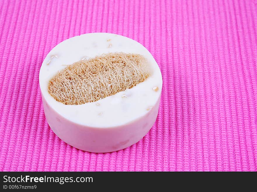 Soap and exfoliator on a pick background - spa products