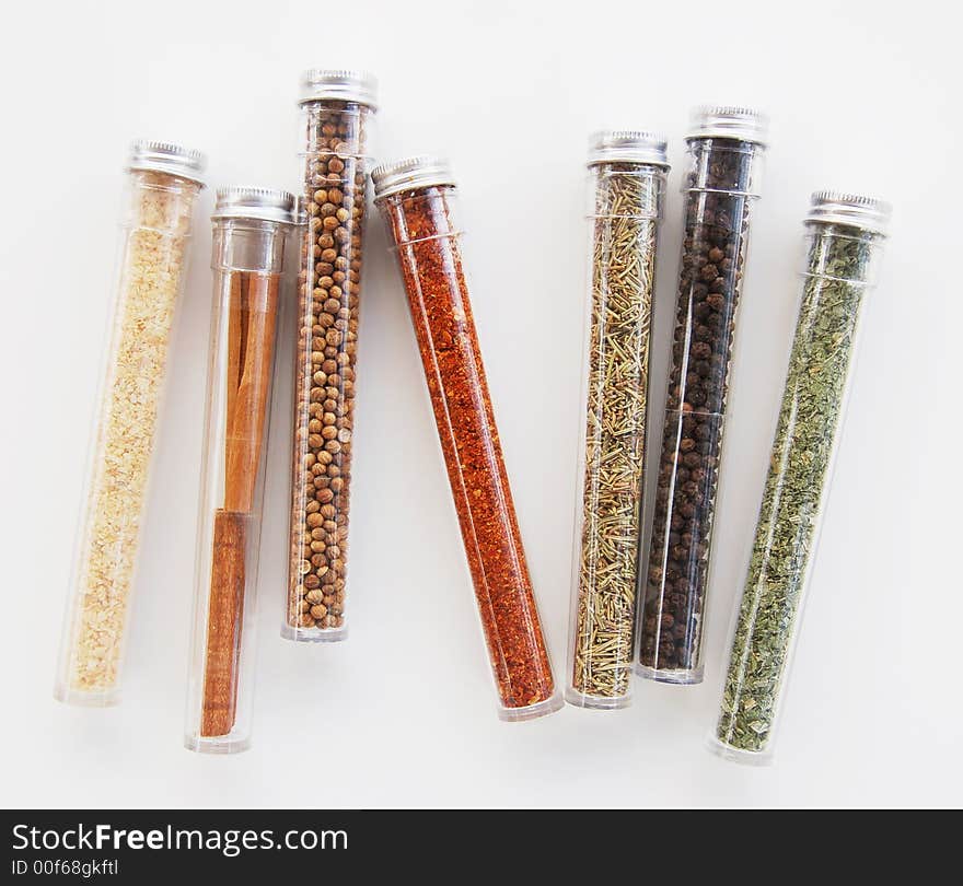 A variety of seven different spice containers against a white background. A variety of seven different spice containers against a white background.