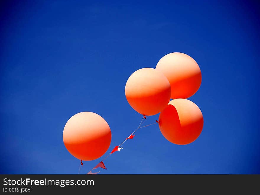 Orange Balloons Floating in the Spring Sun