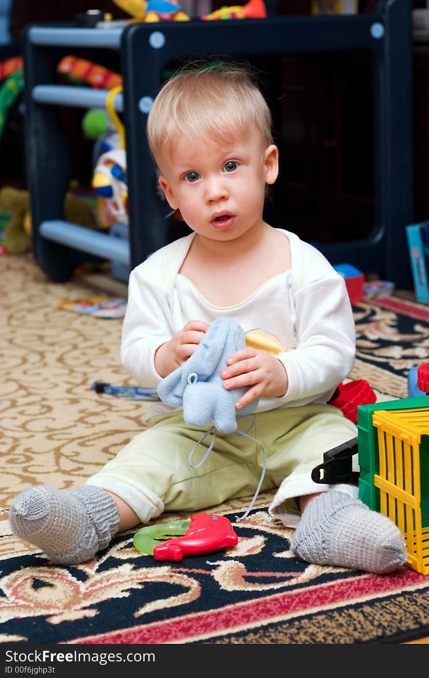 Cute little boy sitting on the floor playing toys. Cute little boy sitting on the floor playing toys