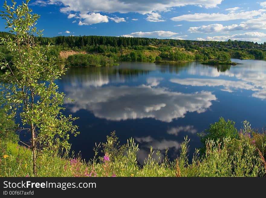 The white fluffy clouds reflected in water