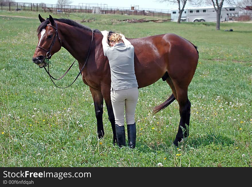 Woman trying to mount horse bareback in field. Woman trying to mount horse bareback in field.